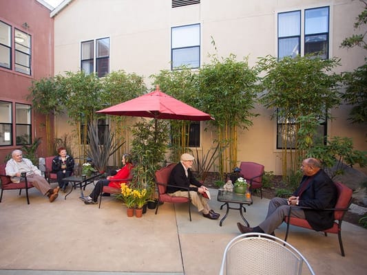 Residents socializing in a courtyard with greenery