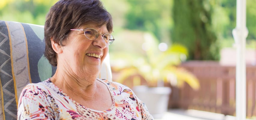 Senior woman smiling in an outdoor space
