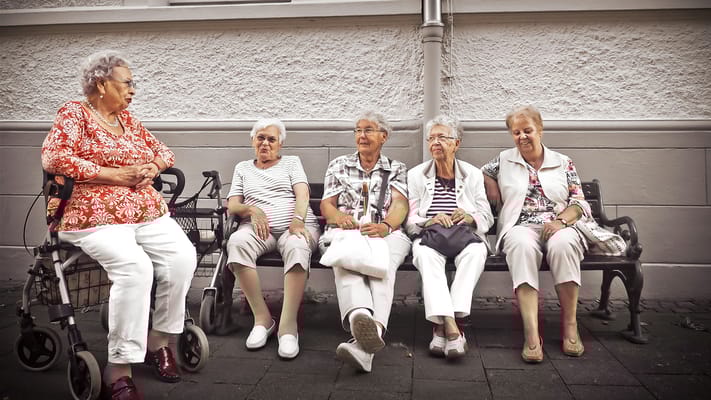 Residents seated together on a bench enjoying conversation