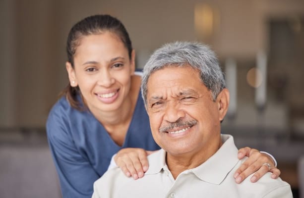 A caregiver and resident smiling together in a cozy interior