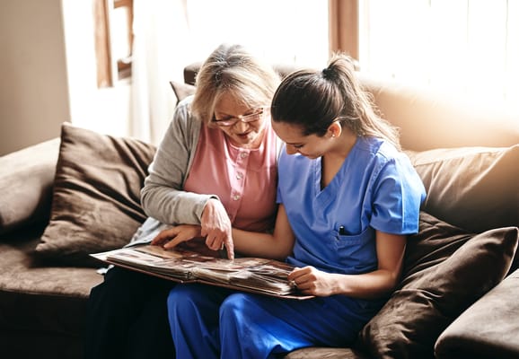 A resident and staff member looking at a photo album