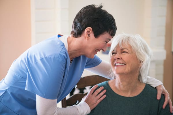 Caregiver and resident sharing a joyful moment inside