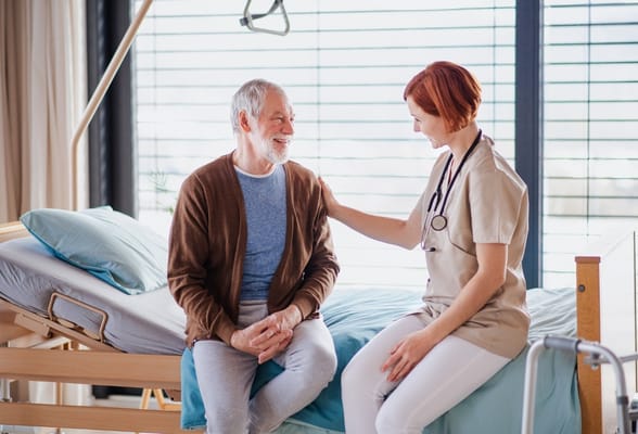 A caregiver interacting with a smiling resident in a room