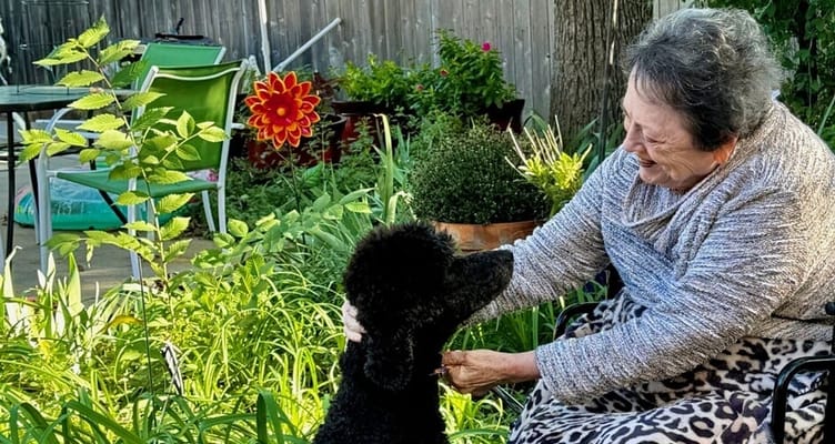 A resident enjoying time with a dog in the garden
