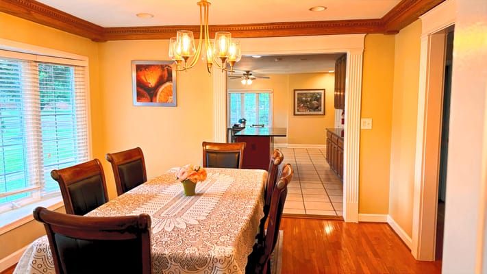 Bright dining area with a large table and chandelier