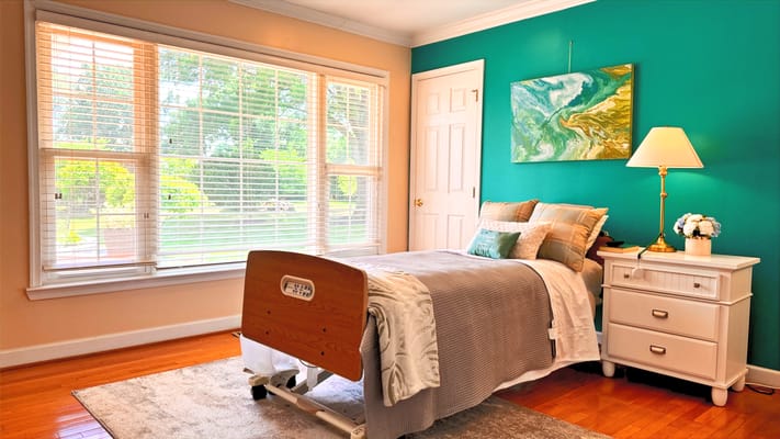 A cozy resident room with a hospital bed and window