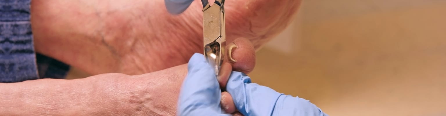 Skilled staff providing nail care to a resident