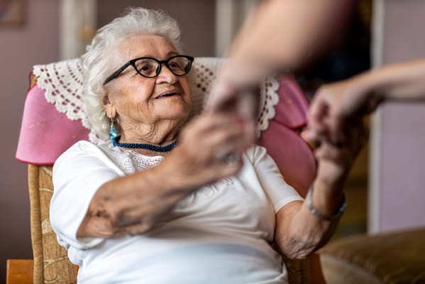 Elderly woman smiling and interacting with a caregiver