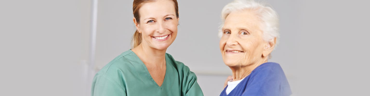 Smiling nurse with elderly resident in a facility