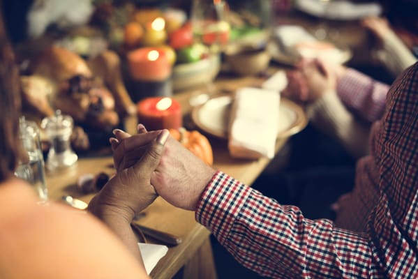 Close-up of hands being held at a dining table