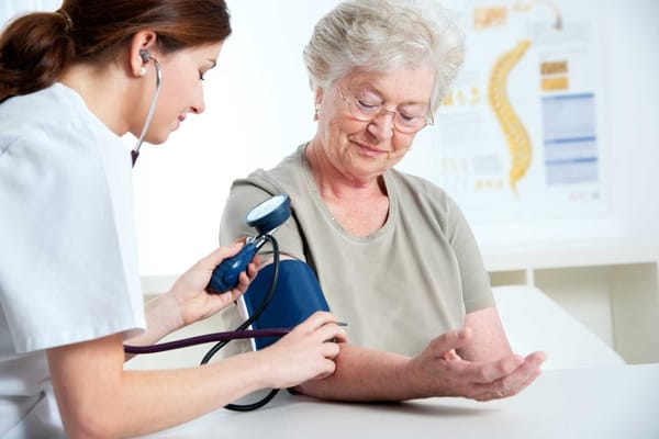 Nurse taking blood pressure of a senior resident