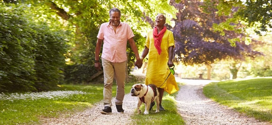 Couple walking a dog on a scenic path