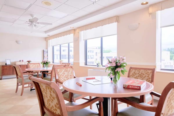 Common area with tables and chairs in a senior living facility