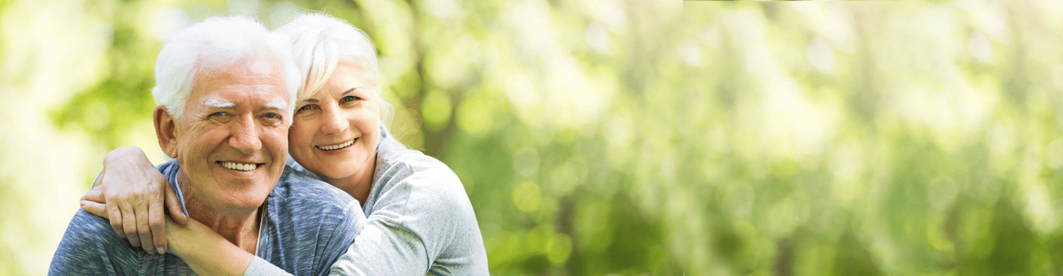 Senior couple smiling in a bright outdoor setting