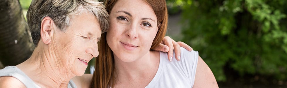 A caregiver and an elderly resident enjoying time together outdoors