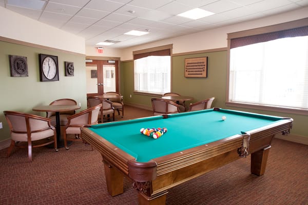 Interior game room with a pool table and seating