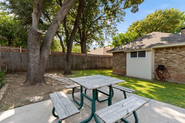 Outdoor seating area with picnic table under trees