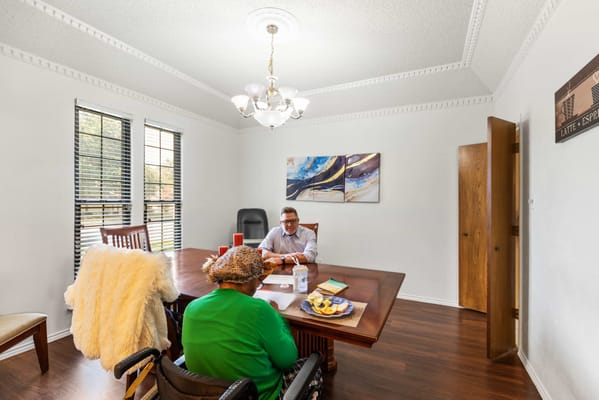 A caregiver assisting a resident in a private meeting room