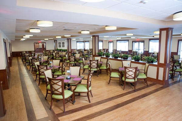 Bright dining room with green chairs and tables