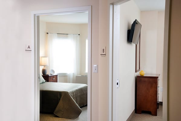 A view of a room with a bed and furniture.