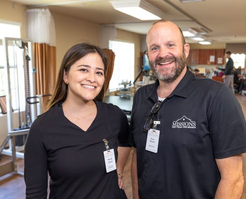 Two staff members smiling in a therapy room