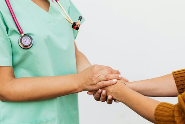 Healthcare professional holding hands with a resident