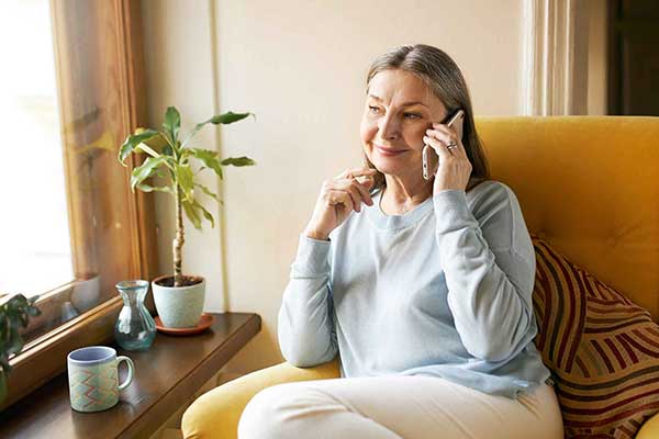 Resident talking on the phone in a cozy chair