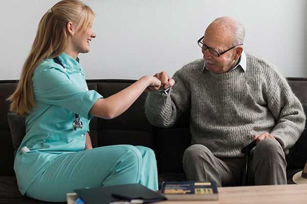 Caregiver interacting with a senior resident in a cozy living space