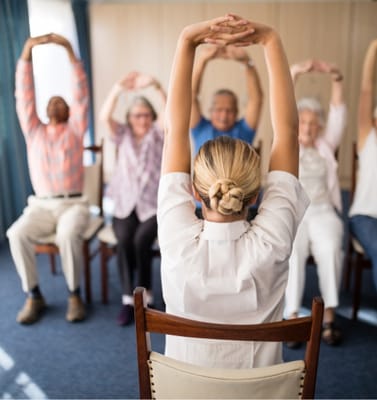 Residents participating in a seated exercise class