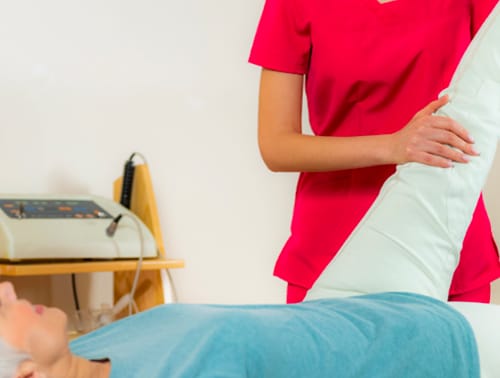 Staff assisting a resident with physical therapy