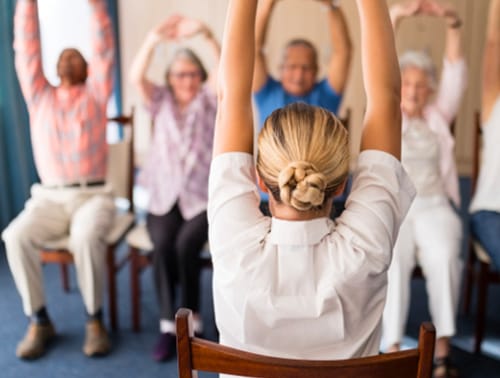 Group exercise session led by staff in a common area