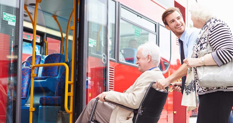 Staff assisting a resident boarding a facility transport bus
