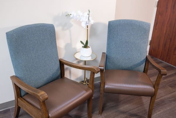 Two chairs and a small table with a flower arrangement