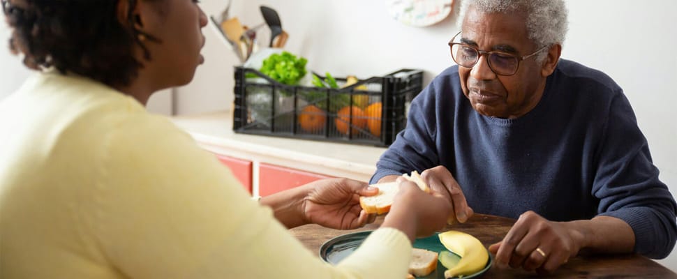 A resident sharing a meal with staff member