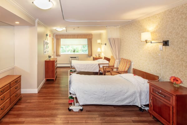 Brightly lit resident room with two beds and furniture