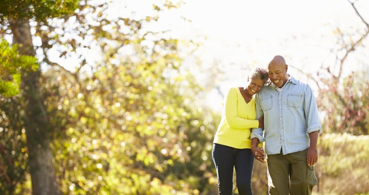 Couple walking hand in hand in a sunny outdoor space