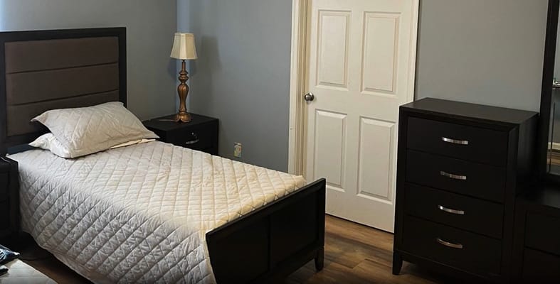 A well-furnished bedroom with a bed, nightstands, and dresser.