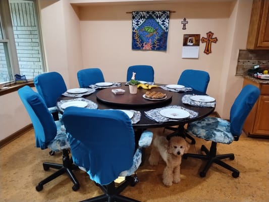 Dining table set for a meal with a dog nearby