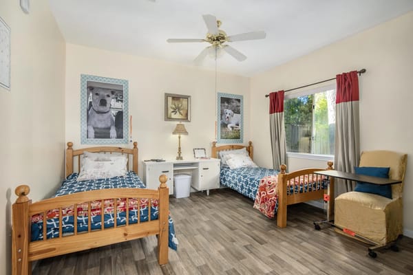 Bright resident room with two beds and decor