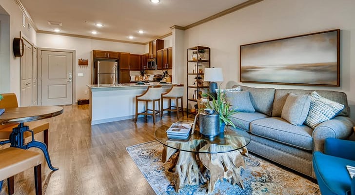 Spacious living room with a sofa, coffee table, and kitchen in the background