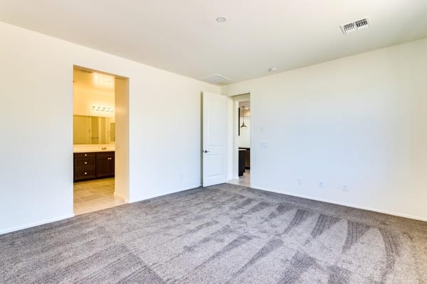 A spacious living area with a doorway leading to a bathroom