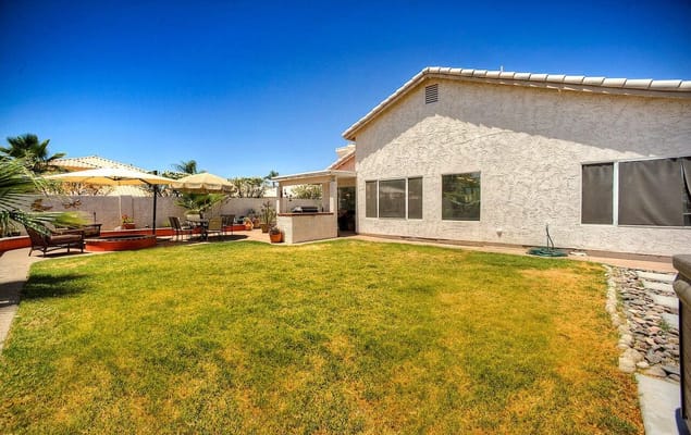 Spacious backyard with seating and umbrellas at Angel's Senior Care