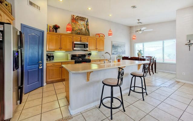Bright kitchen with wooden cabinets and bar stools