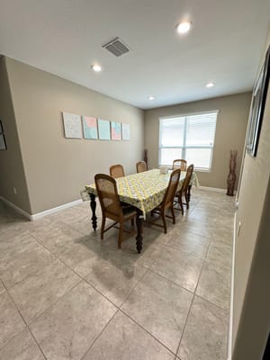 Bright dining area with a large table and art on the walls