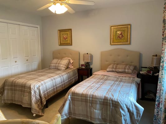 Two twin beds in a shared bedroom with bedside tables and decor.