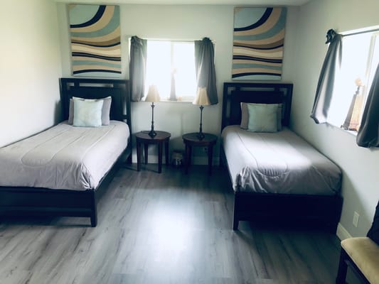 A well-furnished resident room with twin beds and lamps