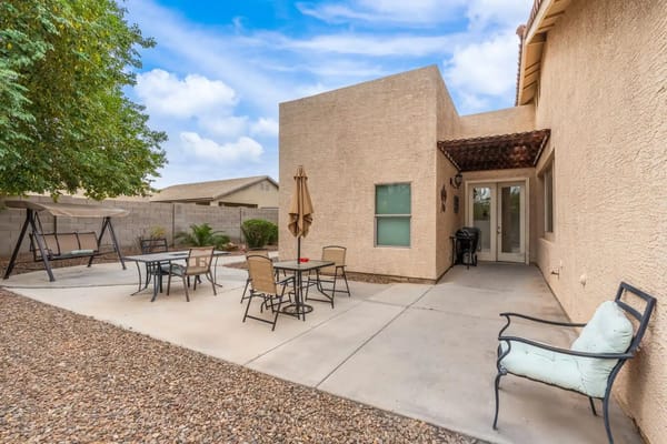 Outdoor patio area with seating and a swing