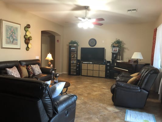 Cozy living room with a couch, TV, and piano.