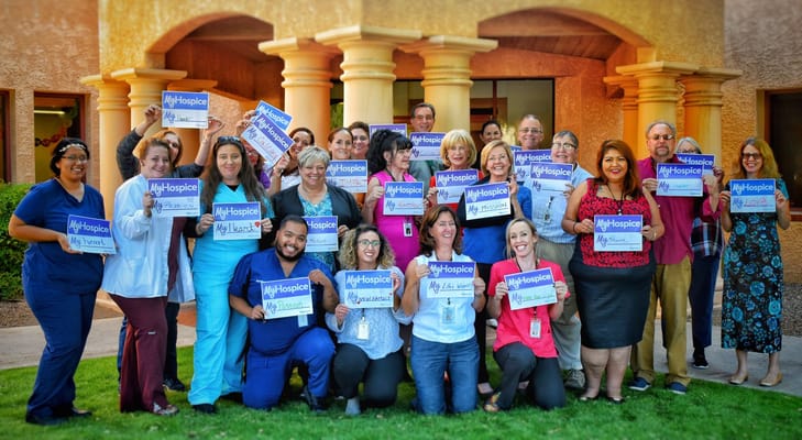 Staff holding signs for hospice awareness outside