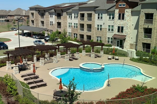Outdoor pool area with seating and shaded structures